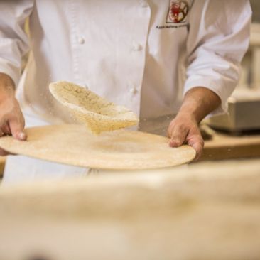 Der Teig wird auf dem Holzbrett geschüttelt